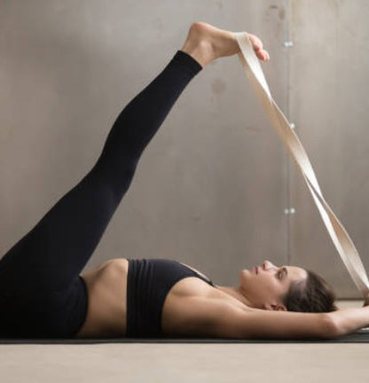 Person using a beige yoga strap